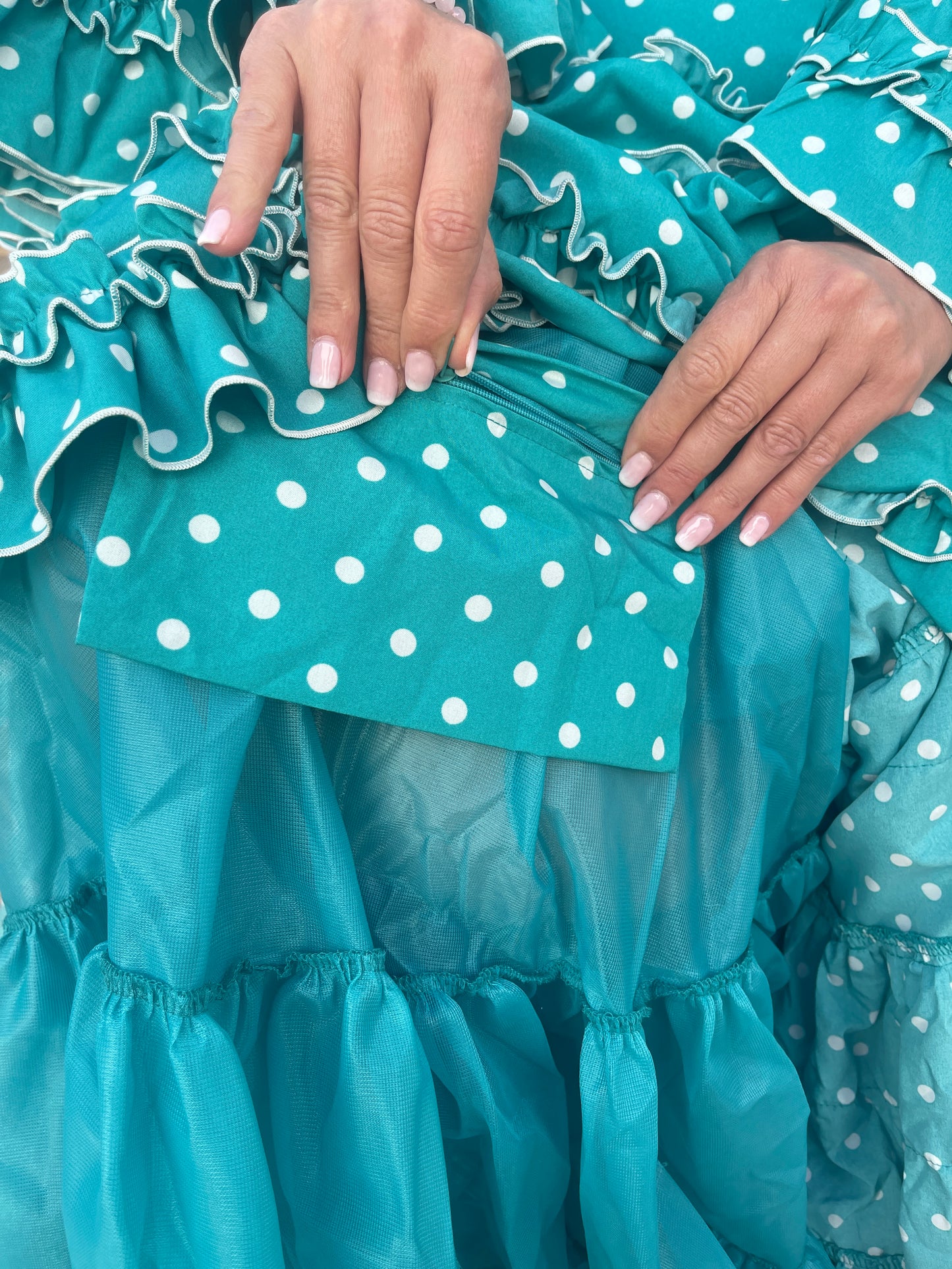 Bolsillo interior del traje de flamenca turquesa con círculo blanco.